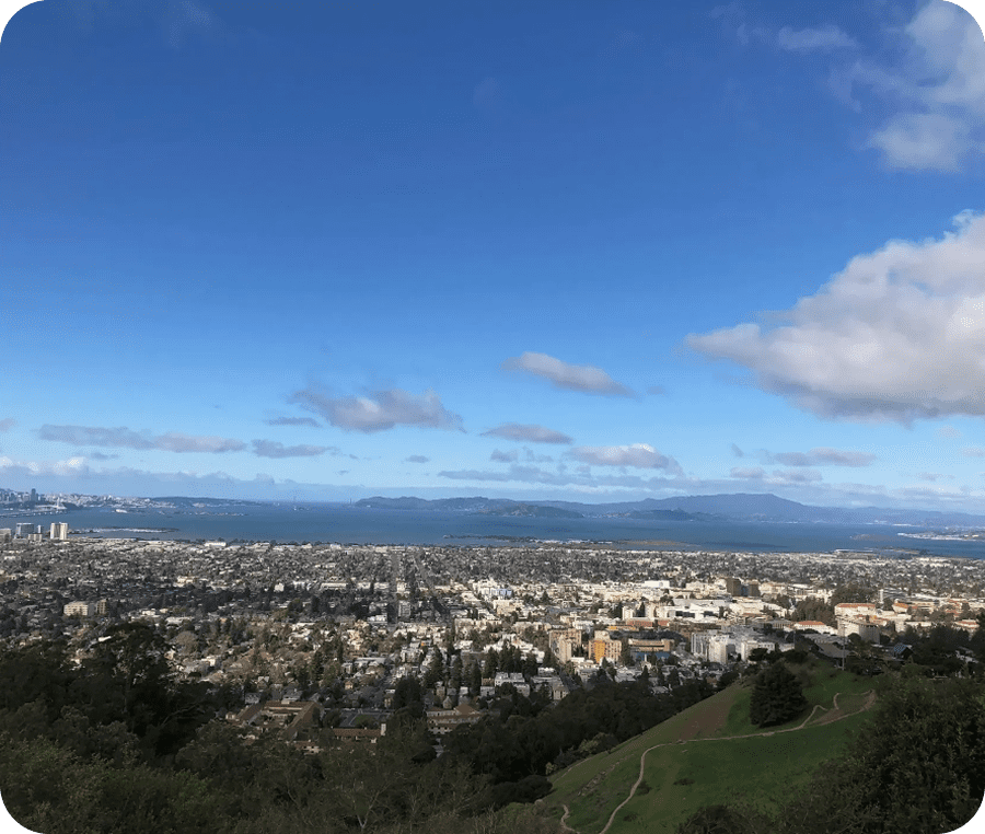 Cityscape under a blue sky with scattered clouds.